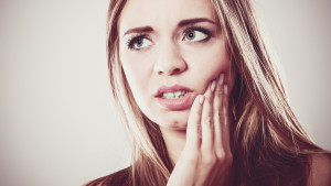 Dental care and toothache. Closeup young woman face worried girl suffering from tooth pain