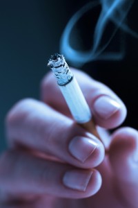 Woman's hand, holding a lit cigarette