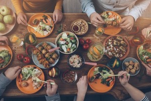 Enjoying dinner with friends. Top view of group of people having dinner together while sitting at the rustic wooden table