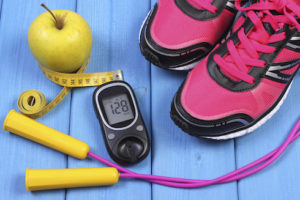 Glucometer, sport shoes, fresh apple and accessories for fitness